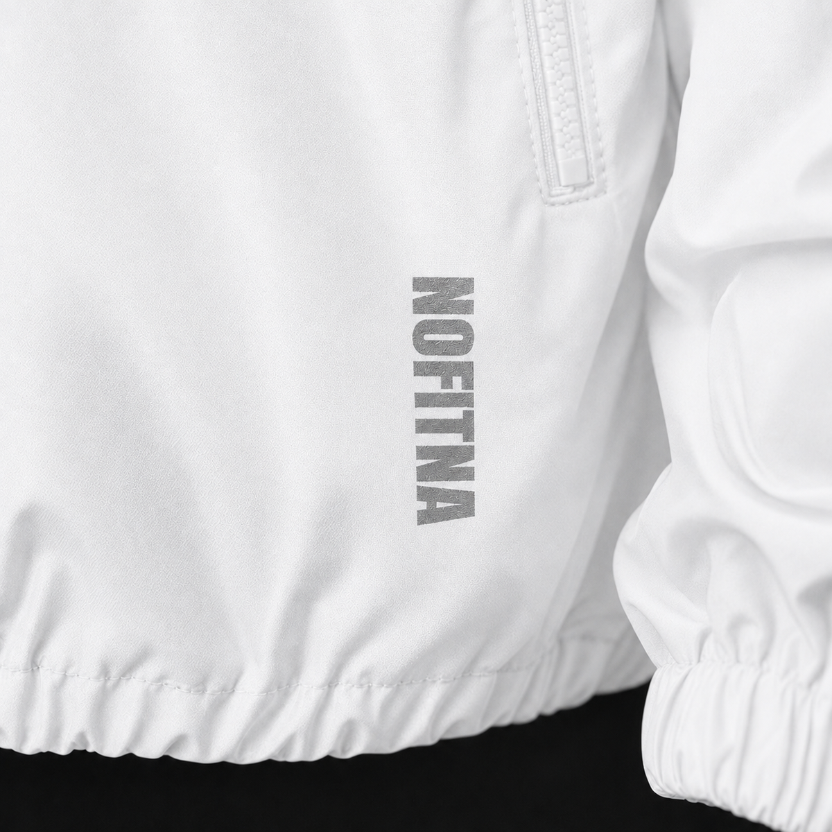 Wordmark NO FITNA réfléchissant sur veste blanche, détail