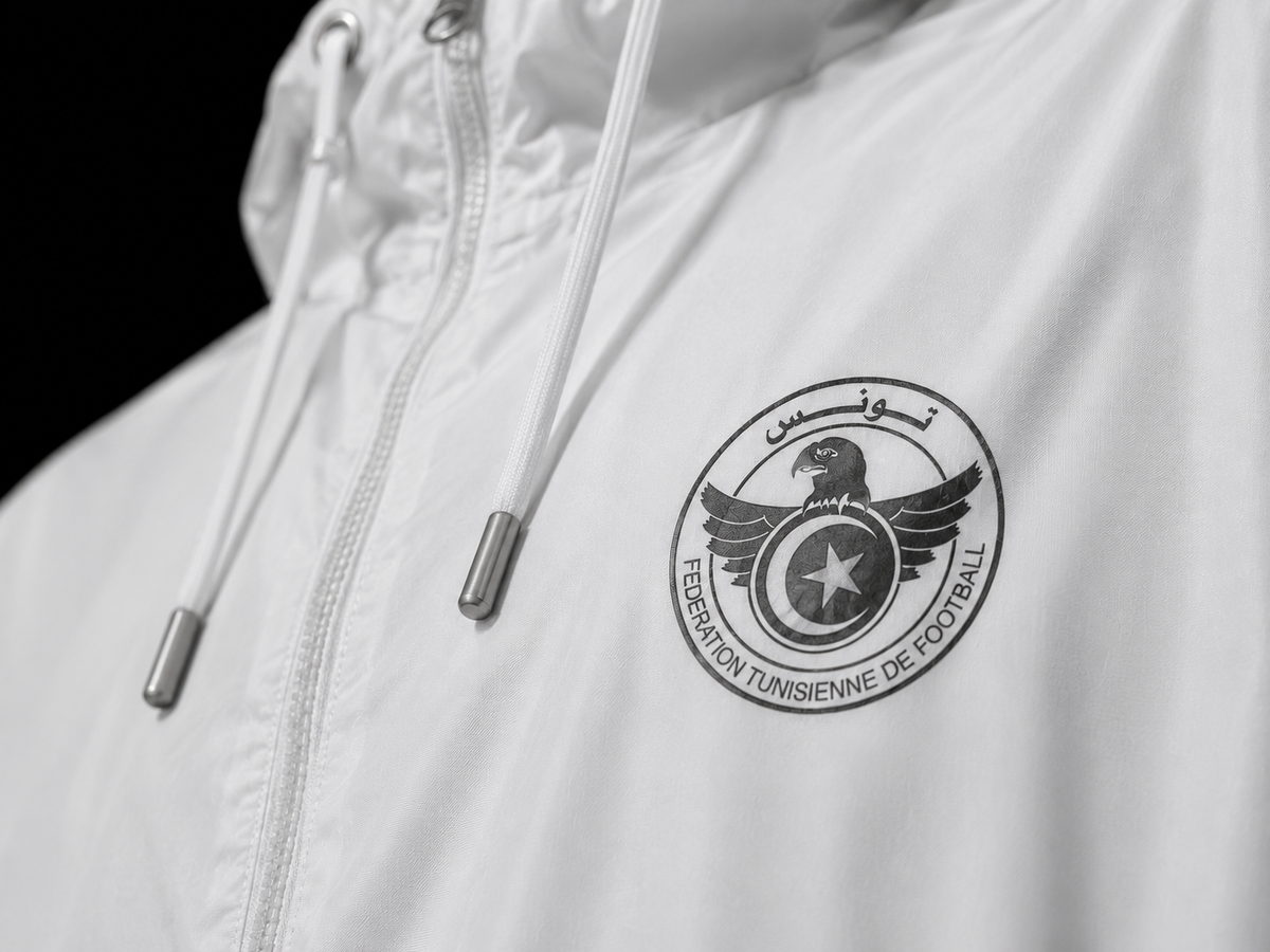 Logo Tunisie NO FITNA réfléchissant sur veste blanche, détail